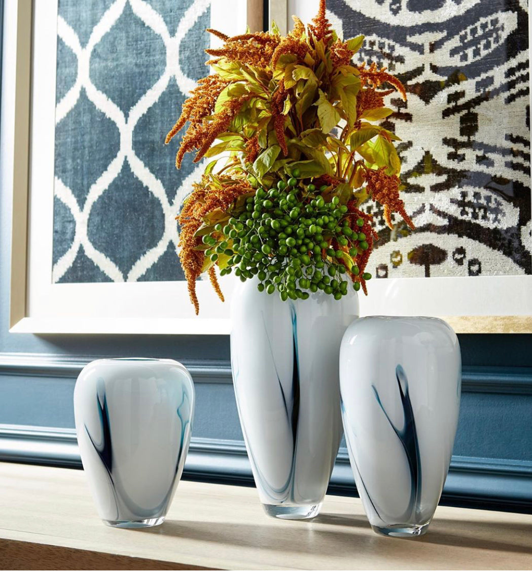 Freshen your home’s look, add a pop of color to your tabletop ensemble with the Deep Sky vase. Available in three different size options, these subdued white accents feature a subtle touch of blue. These contemporary vessels are ideal for your spring floral arrangements. Perfect for any style design: contemporary, traditional, or transitional, these glassware pieces will fit your needs.  LRG:H14.25”W7...MED:H 11”W 6.2”weight 8.4lb...SML: H9” W6.5”