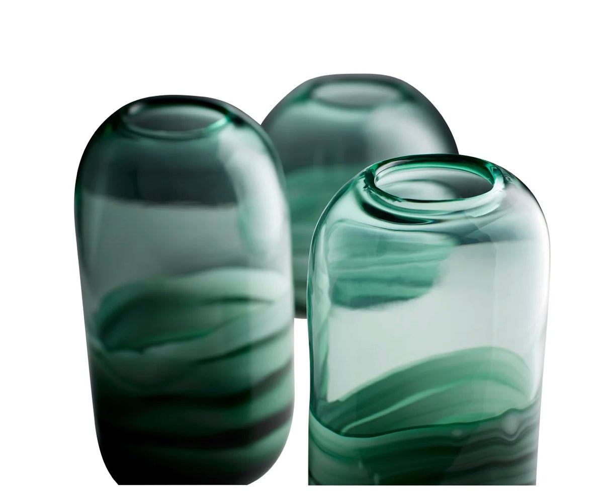 "Add an abstract design to your tabletop ensemble with the Torrent vase. Available in three different size options, these subdued white and green swirled accents, feature a translucent surface from top to bottom. This contemporary vessels is ideal for your seasonal floral arrangements. Constructed from 100% recycled glass, this vessel is suitable for any style design: modern, traditional, or transitional. Adorn your dining room table with one of these vases, or welcome your guests with a trio atop your entr