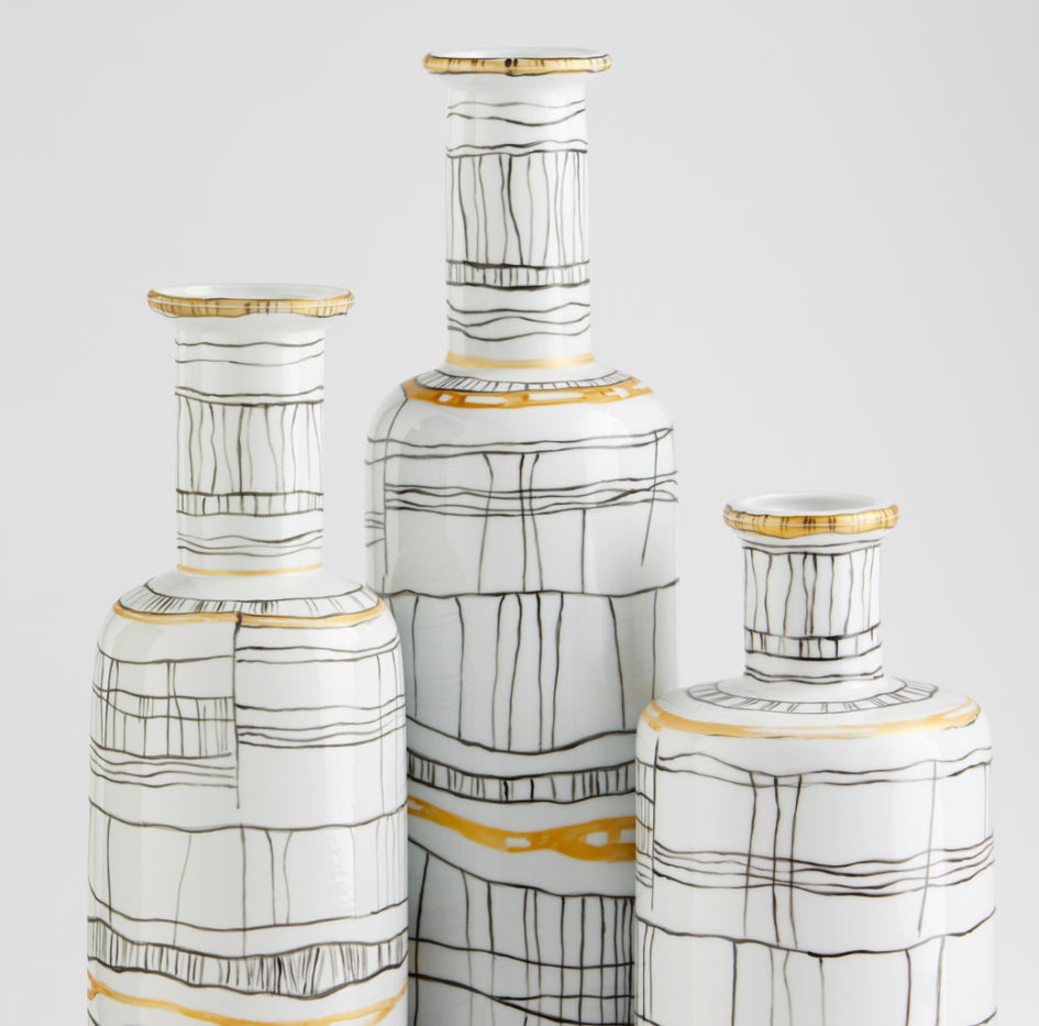 A glossy white base boasts irregular calligraphic lines with gold metallic embellishments, giving the Lindus vases an instinctively artful overture. Intersecting lines weave together to create a display of rudimentary elegance on a slender, cylindrical body. The Lindus vases are composed of ceramic and are available in three sizes.  Artisan Produced: Design of random caligraphic lines with gold metalic embellishments.  Dimensions: L 5.75 X W 5.75 X H 23.25 X Dia 5.75